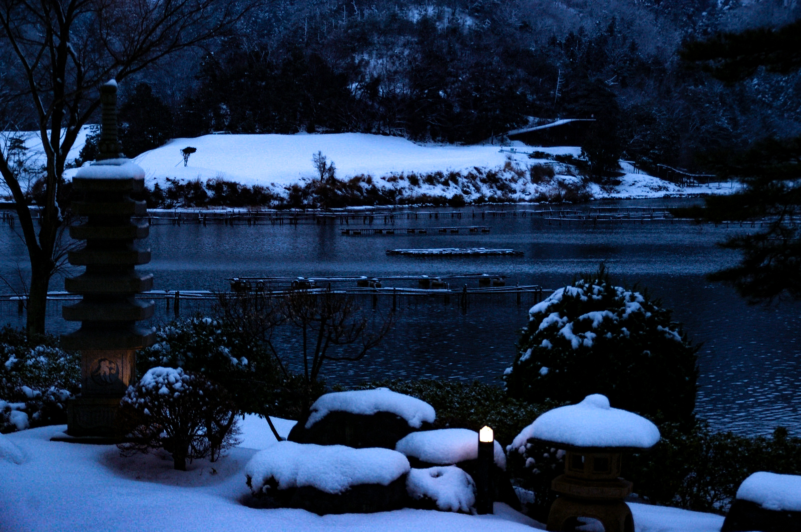 夕暮れの日本庭園、趣のある雪景色の写真