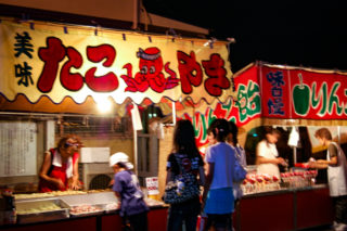 夜店でたこ焼きを待つ子どもたち