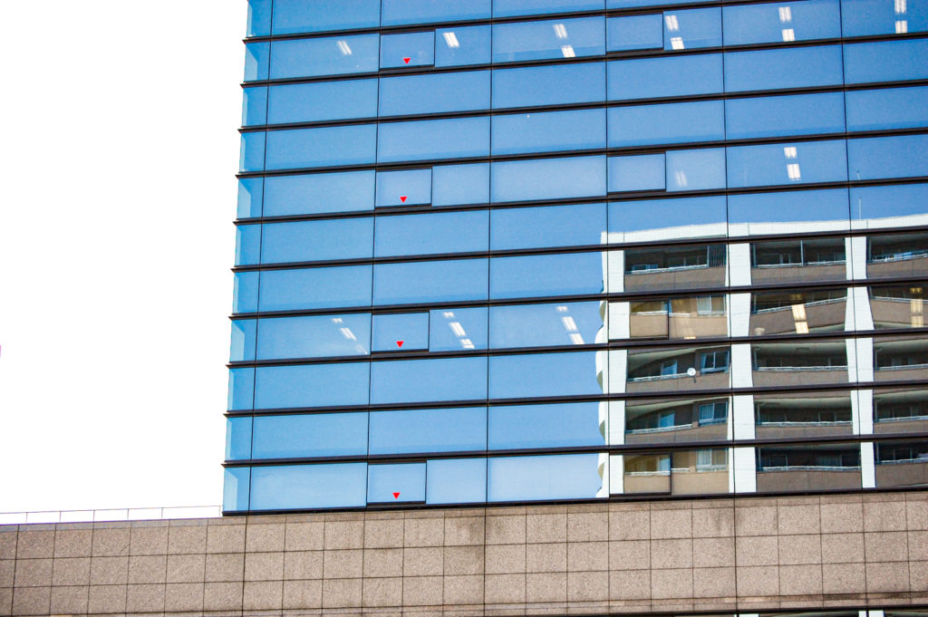 鏡のように反射するオフィスビルのガラス窓