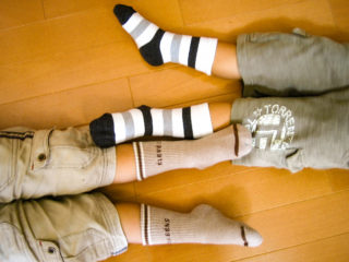 双子の子供が寝そべった時の足の写真